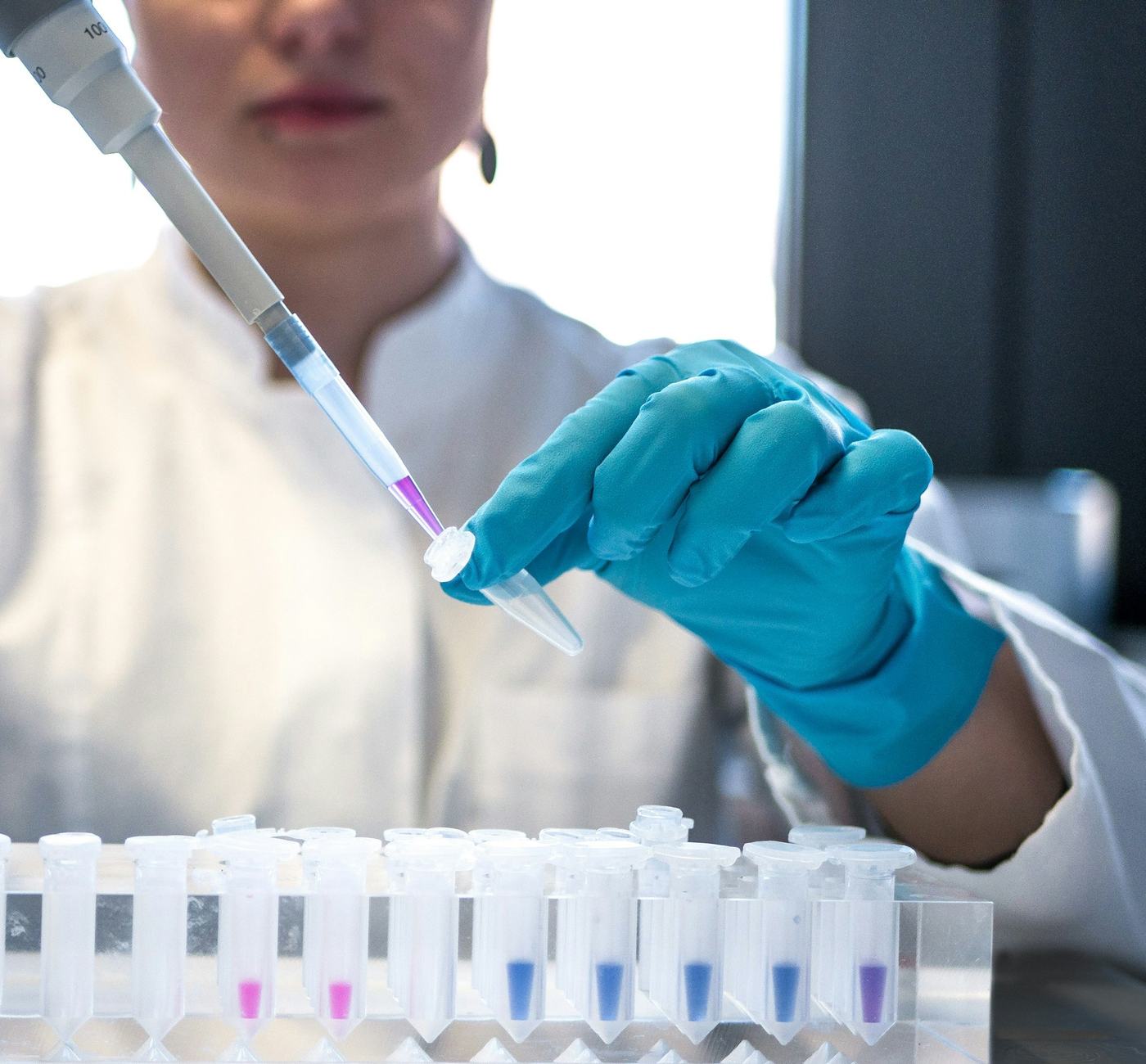Lab technician transferring a sample into test tubes with a pipette